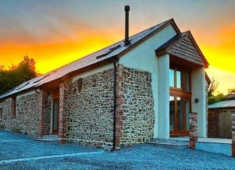 A stone-built Exmoor barn conversion at sunset.