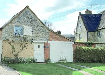 Gable end of an old bothy converted to a holiday cottage with a large lawned garden.