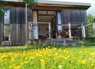 Decked entrance, outdoor dining area and meadow setting.