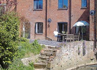 A 3-storey, brick-built mill conversion alongside the mill race.