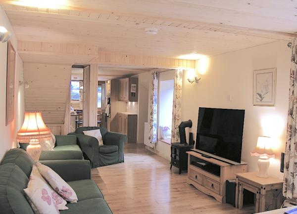 Lounge with a sofa, 2 armchairs, TV and table lamps.