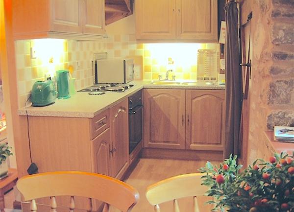 A fitted kitchen with electric cooker and microwave.