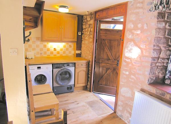 Utility room with washing machine and tumble dryer.