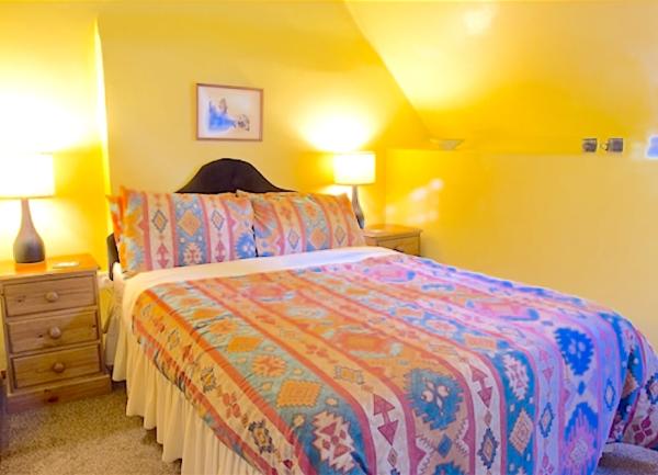 Double bedroom with bed and twin bedside cabinets with table lights.