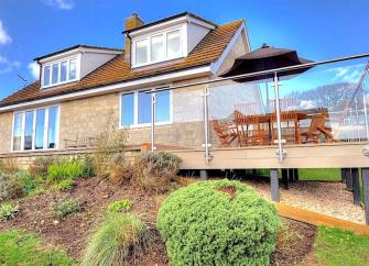 A large multi-windowed chalet bungalow in Charmouth with an extended plate-glass walled deck