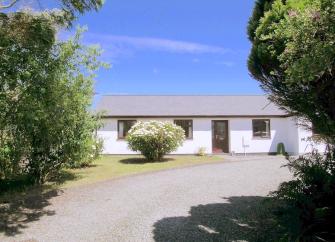 A wide tree-lined drive leads to a long, Boscastle holiday bungalow.