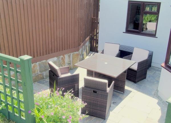 Sunny patio with table and chairs.