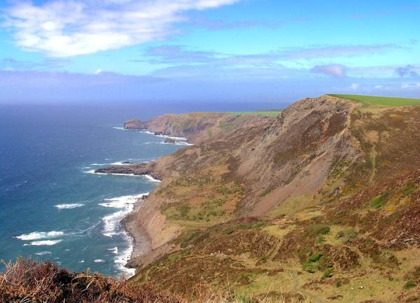 Rocky North Cornish coastline with waves crashing against cliffs.