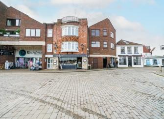 A row of contemporary shops with two floors of apartments above.