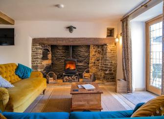 A lounge with twin sofas, inglenook fireplace and French windows.