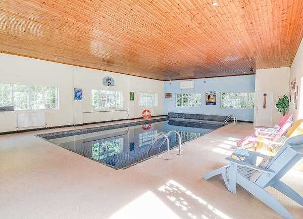 Sun loungers overlook an indoor swimming pool.