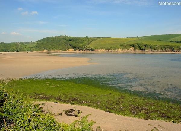 Mothecombe beach overlooking an estuary towards sand dunes and fields.