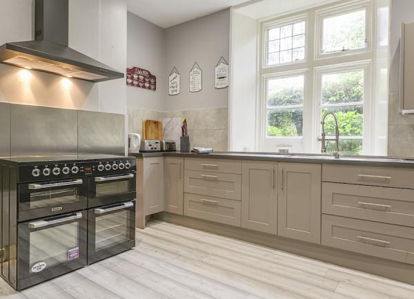A kitchen with contemporary fitted units and a two range cookers.