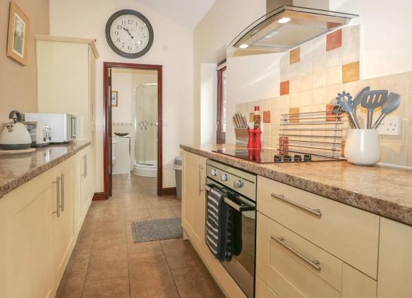 Fitted galley kitchen with oven, hob and microwave.