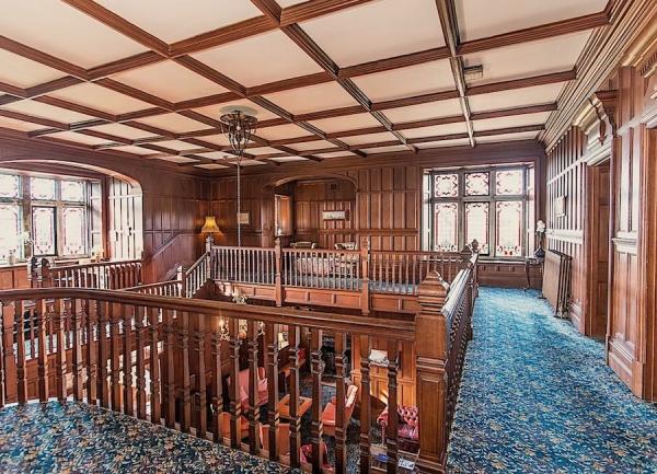 A 4-sided oak-panelled galleried landing.