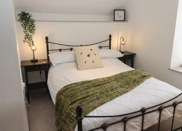 A double bedroom with a bed and bedside tables with table lamps