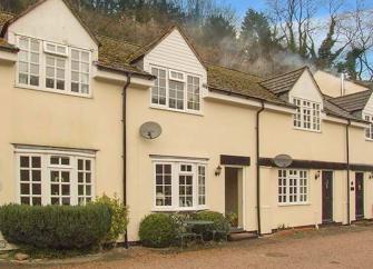 Exterior of a large cottage with 4 first-floor dormer windows.