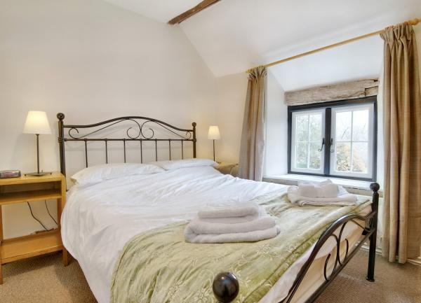 An iron-framed double bed flanked by twin bedside table with table lamps.