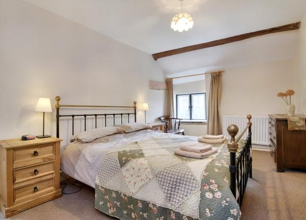 Double bedroom with a brass bed, twin bedside cabinets with table lamps and a dressing table.