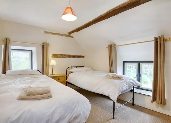 A dual-aspect twin bedroom with towel sets on each bed.