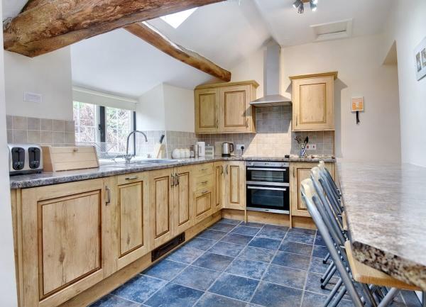 A kitchen with fitted cuboards including an oven and intergrated dishwasher.