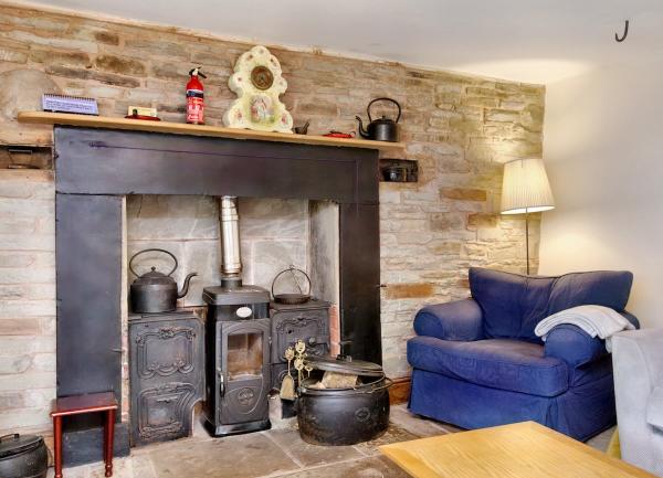 A lounge fireplace with a Victorian range and an armchair on one side.