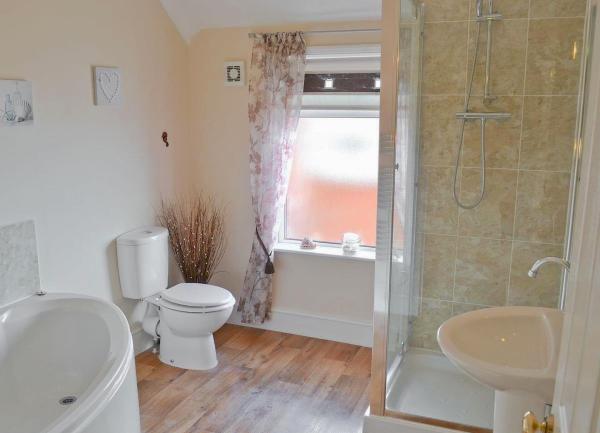 A bathroom with a bath, sshower, wash basin and WC.