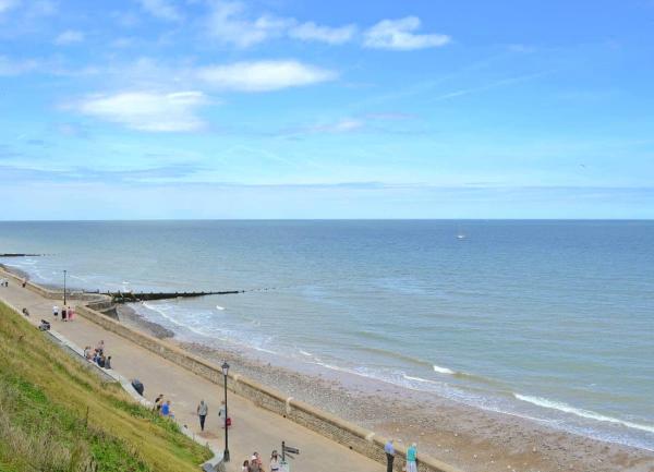 A sandy beach at high tide with a calm sea.
