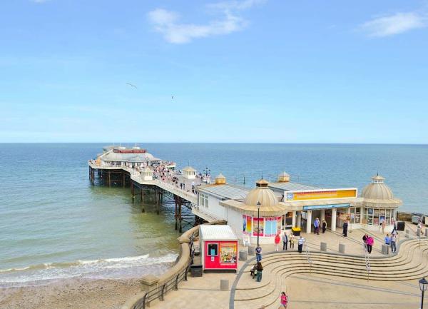 Cromer pier with a Pavilion at the seaward end stretches from a promenade into the ocean 