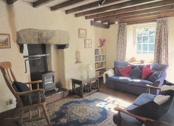 Sitting Room with an inglenook fireplace, sofa and armchairs.