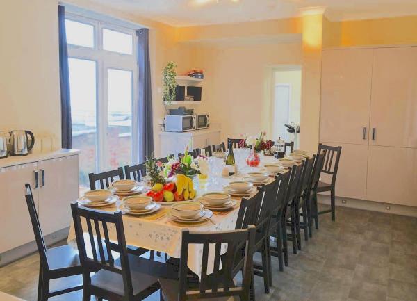 A long dining-table with chairs in a kitchen.