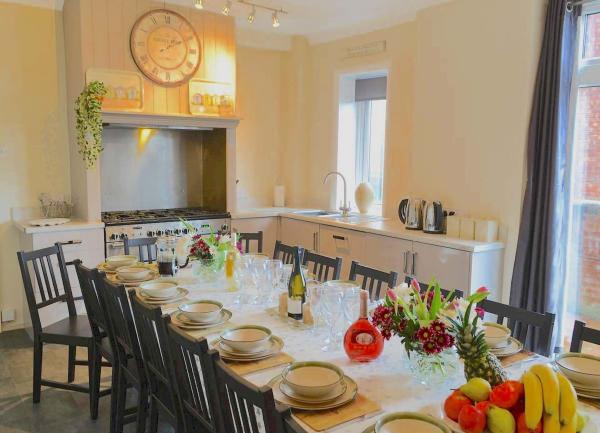 A large dining table in a kitchen laid for dinner.