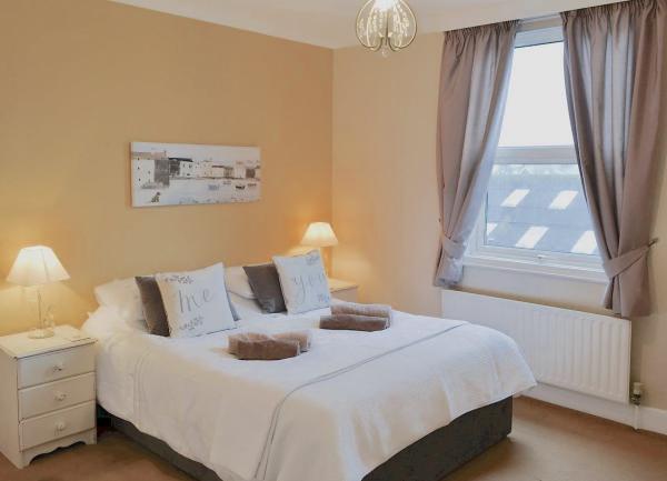 A double bedroom with a bed and twin towel sets o the bed. 