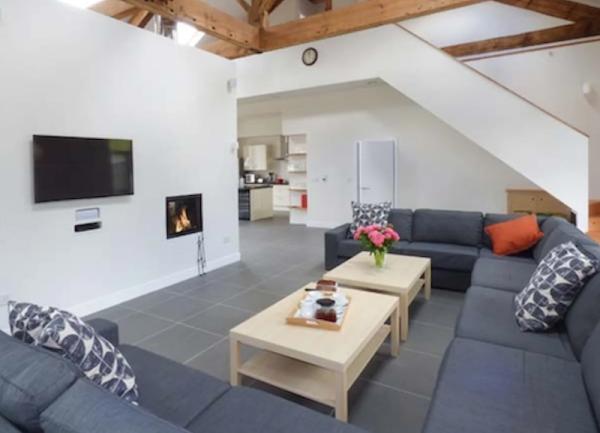A beamed lounge with wrap-around sofa and widescreen TV