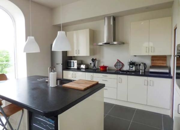 A fitted kitchen with wall-mounted units and a breakfast bar.