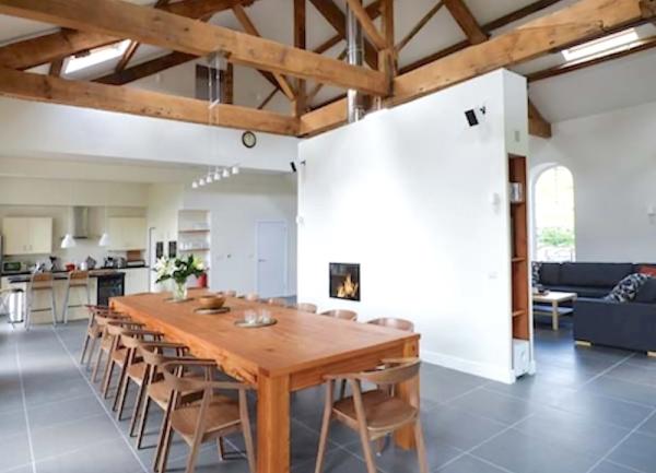 A dining area with a long wooden table with 16 chairs.