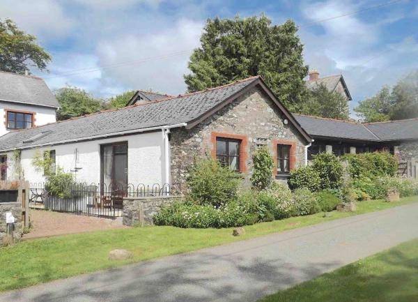 Exterior of a stone-built, single-storey holiday cottage and garden.