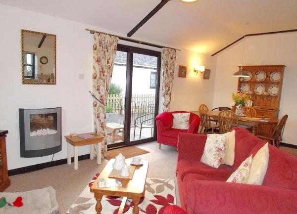 Lounge with sofa, armchair, woodburner and French Windows