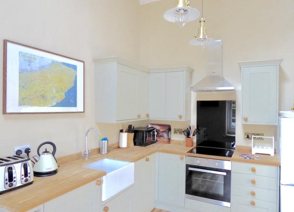 Kitchen worktops with oven, butler sink and appliances.