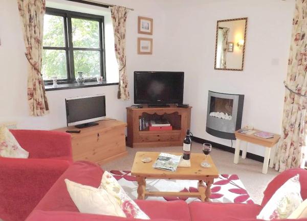 Lounge corner with TV, desktop screen, coffee table and sofa.