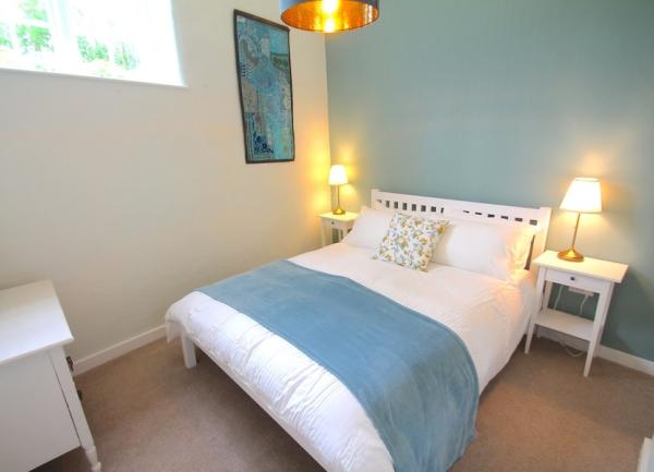 Double bedroom with bed and bedside tables with table lamps.