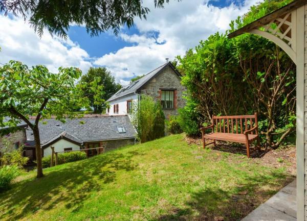 An Exmoor holiday cottage nestles below a lawn that slopes down to it.