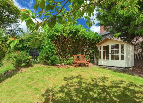 Exmoor country cottage summerhouse in the garden under a tree.