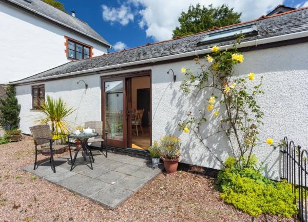 The patio of a Dulverton holiday cottage with outdoor chairs and table.