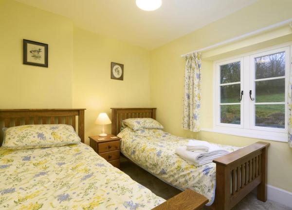 Twin bedrom with beds and bedside cabinet with table lamp.