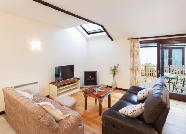 Lounge with 2 sofas, coffee table and TV in a Dulverton cottage.