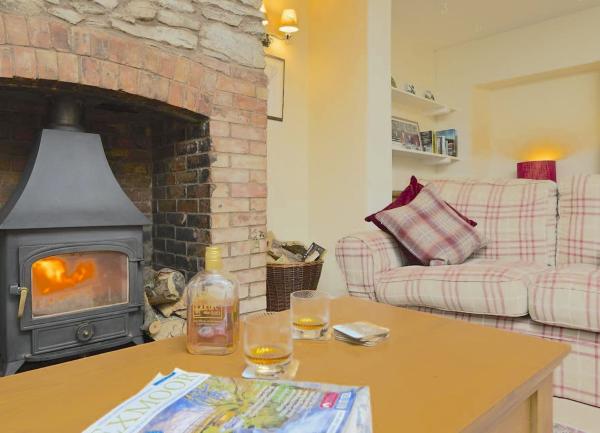 An Exmoor cottage lounge with woodburner, sofa and coffee table.