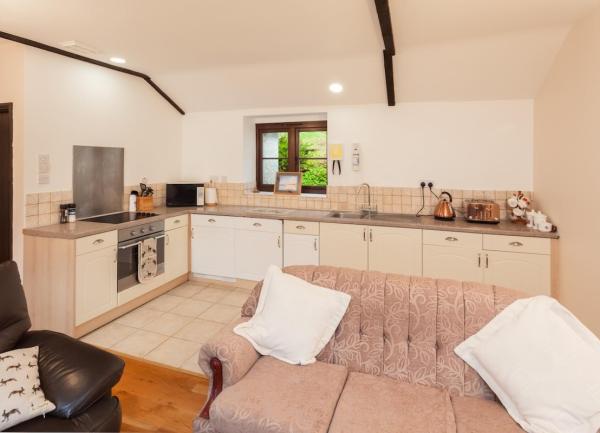 A fitted kitchen with an oven, toaster and microwave.