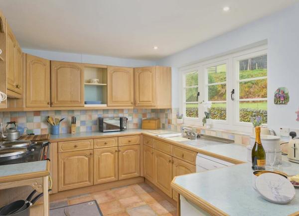 A fitted kitchen in n Exmoor cottage with many built-in appliances, toaster and microwave.