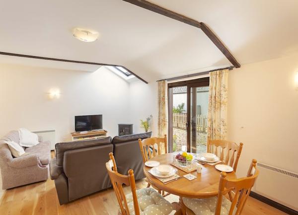 Lounge with sofas and TV with a diing table and chairs in front of it.